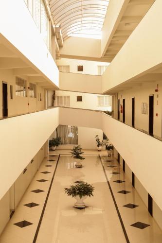 an empty hallway in a building with potted plants at Tezla Hotel in Primavera do Leste