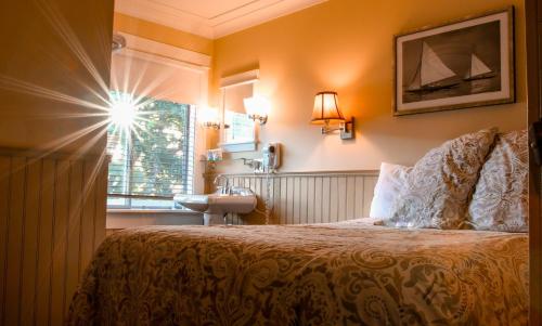 a bedroom with a bed and a window at Salt Spring Inn in Ganges