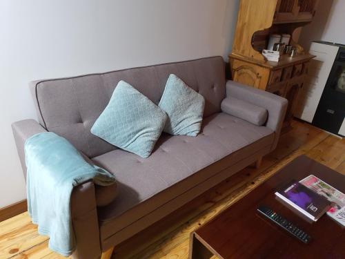a couch with two pillows on it in a living room at Apto La Fabrica de Paños Brihuega in Brihuega