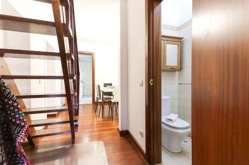 a bathroom with a toilet and a staircase in a room at Avenida da Liberdade Duplex by Homing in Lisbon