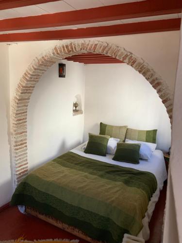 a bedroom with a bed with an archway at Riad Darbask in Essaouira