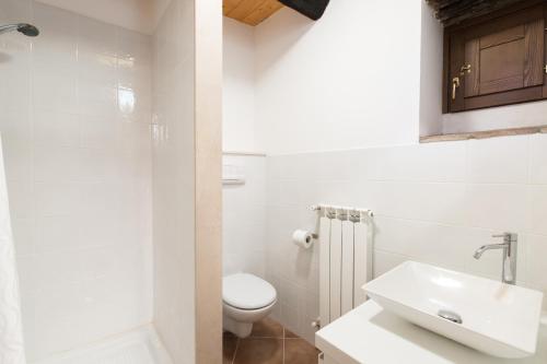 La salle de bains blanche est pourvue de toilettes et d'un lavabo. dans l'établissement Oleandro 1, à Ripabottoni