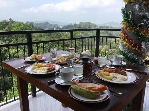 a table with plates of breakfast food on a balcony at Villa Forest View - No: 50/17 in Kandy