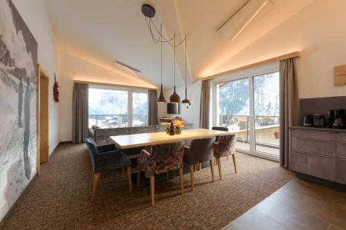jadalnia ze stołem i krzesłami w obiekcie Arula GmbH w mieście Sankt Anton am Arlberg