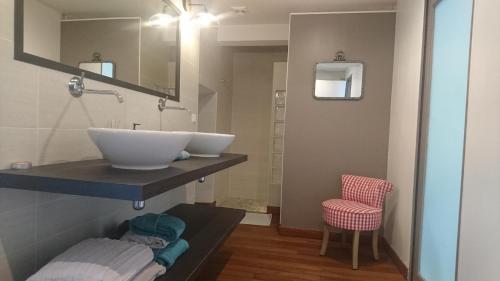 łazienka z umywalką i czerwonym krzesłem w obiekcie Le clos de CINACLE w mieście Ogeu-les-Bains