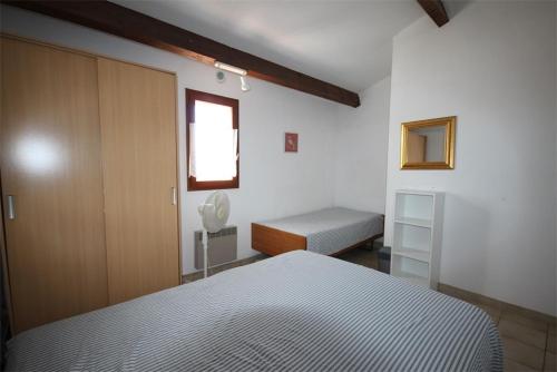 - une chambre avec un lit, un placard et une fenêtre dans l'établissement Villa d'angle, 5 couchages, 2 chambres etage, terrasse Sud parking dans résidence sécurisée, WIFI , piscine commune 400m de la mer LRJP123, à Portiragnes