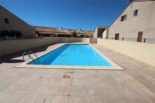 une piscine au milieu d'un immeuble dans l'établissement Villa d'angle, 5 couchages, 2 chambres etage, terrasse Sud parking dans résidence sécurisée, WIFI , piscine commune 400m de la mer LRJP123, à Portiragnes