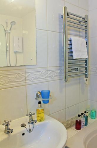 a bathroom with a white sink and a mirror at The Cottage B&B in Porlock
