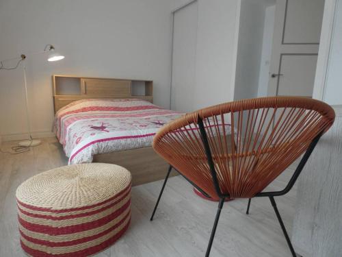 a bedroom with a chair and a bed at La Surprise in Étaples