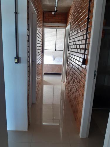 a hallway with a brick wall and a bedroom at Casa Esquina do Mar in São Francisco do Sul