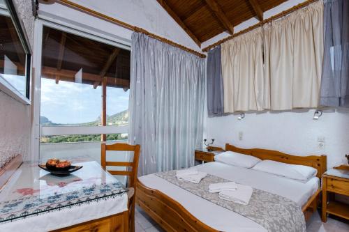a bedroom with two beds and a table and a window at Aqua Marine in Falasarna