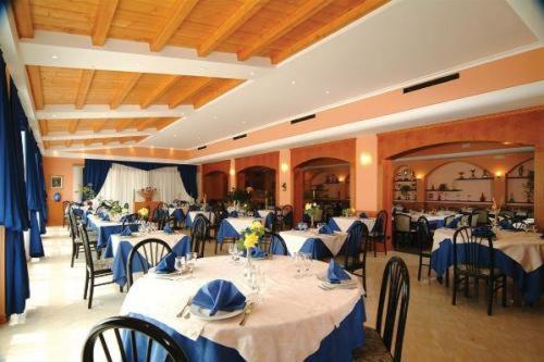 a banquet hall with tables and chairs with blue table cloth at Lo Scoiattolo in Massino Visconti