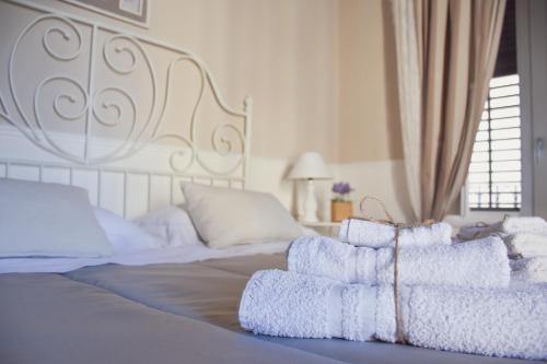 a bed with white sheets and towels on it at Dimora San Domenico in Palermo
