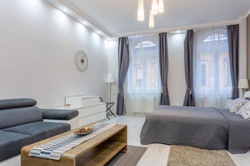 a living room with a bed and a couch at Goldcentral Apartment Grand Boulevard in Budapest