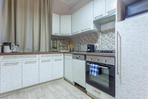 a kitchen with white cabinets and a stove top oven at Goldcentral Apartment Grand Boulevard in Budapest