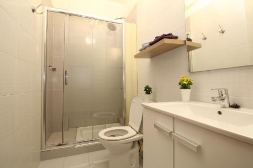 y baño con ducha, aseo y lavamanos. en Comfortable apartment with character in the old town en Palma de Mallorca
