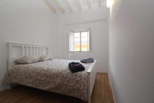 biała sypialnia z łóżkiem i oknem w obiekcie Comfortable apartment with character in the old town w Palma de Mallorca