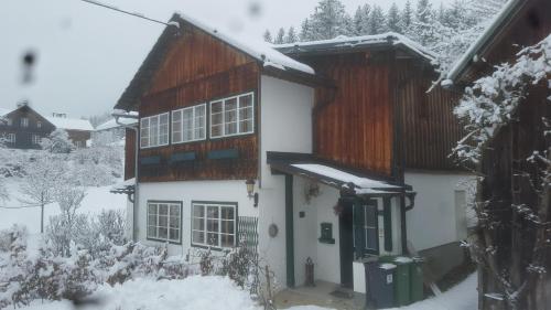 a white house with snow on the roof at Haus Familie Säckl in Altaussee