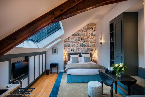 a bedroom with a bed and a tv in a room at La Petite Folie in Honfleur