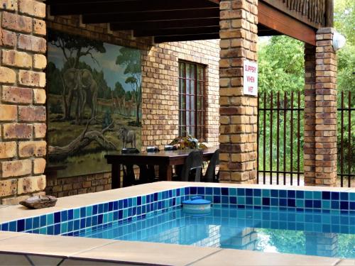a swimming pool in a house with a painting on the wall at Weltevrede Lodge - Self Catering Houses in Marloth Park