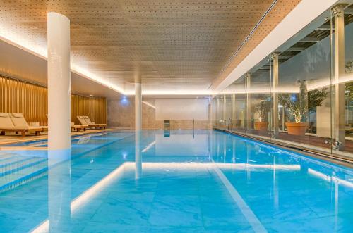 a large indoor swimming pool with blue water at Praia do Sal Resort in Alcochete