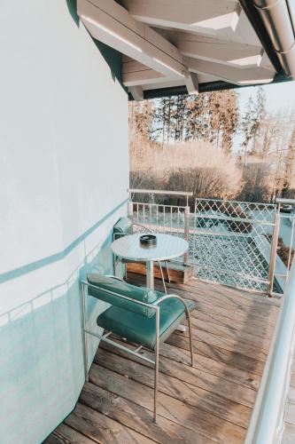 a patio with a table and chairs on a deck at Ferienwohnung Stern-Schürz in Obertrum am See