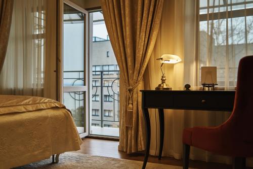 a bedroom with a bed and a desk and a window at Dom Sivre Boutique Hotel in Samara