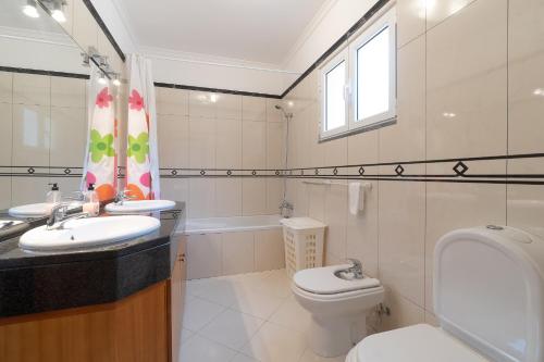 a bathroom with a sink and a toilet and a window at Arco da Calheta Villa in Arco da Calheta