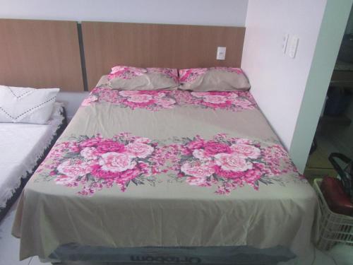 a bed with pink flowers on top of it at Condomínio Lagoa Quente Flat Service-Caldas Novas - FLAT TOP in Caldas Novas