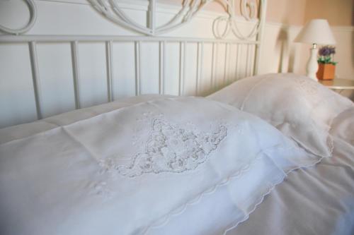 a white bedspread with a flower design on it at Dimora San Domenico in Palermo