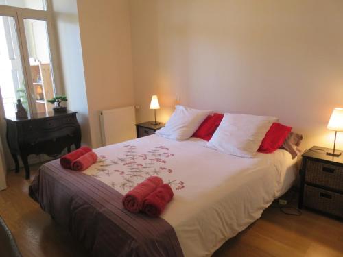 um quarto com uma cama grande e almofadas vermelhas em Le Balcon du Parc, entre Lourdes et Gavarnie em Argelès-Gazost