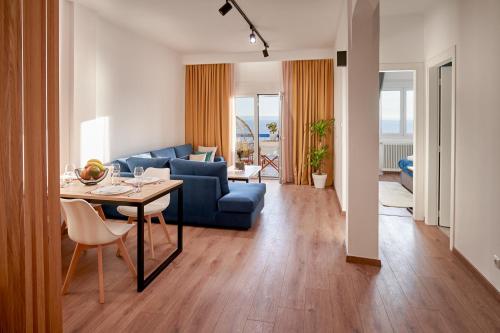 a living room with a blue couch and a table at Seafront Luxury President Suite Aegean Sunset in Thessaloniki