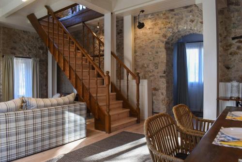 a living room with a staircase and a couch at Secluded Mountain Refuge - Theonimfi Paradise Gem in Dhimitsana