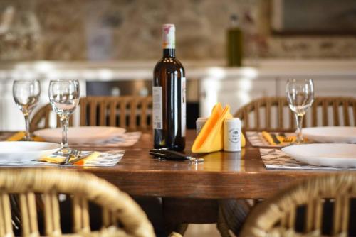a bottle of wine sitting on a wooden table with glasses at Secluded Mountain Refuge - Theonimfi Paradise Gem in Dhimitsana