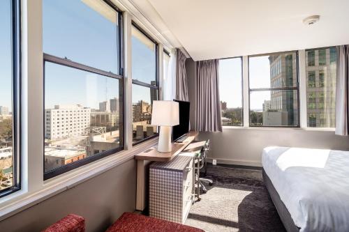 ein Hotelzimmer mit einem Bett und einem Schreibtisch mit Fenstern in der Unterkunft Holiday Inn - Columbia - Downtown, an IHG Hotel in Columbia