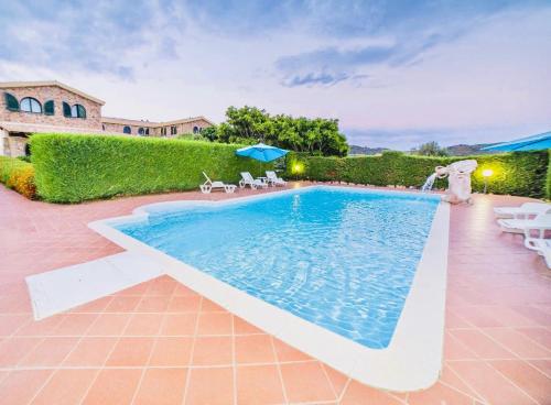 a pool with chairs and umbrellas in a yard at Hotel Janas in Tertenìa