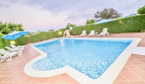 a pool with chairs and umbrellas on a patio at Hotel Janas in Tertenìa