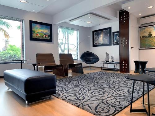 a living room with a chair and a table at Hotel Germânia in Joinville