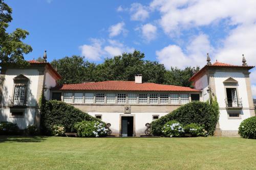 an old house with a red roof and a yard at Casa da Breia in Carregadouro