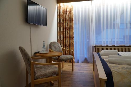 a room with a bed and a table and chairs at Hotel Eleon in Bad Teinach-Zavelstein