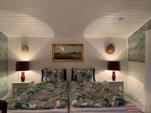 um quarto com uma cama e duas lâmpadas em duas mesas em Farm61 badehotellet i det midtjydske - alder +18 år em Tjele