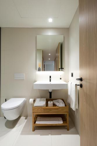 a bathroom with a sink and a toilet and a mirror at Bessa Apartments - Growhome in Porto