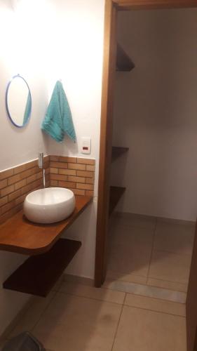 uma casa de banho com um lavatório num balcão com um espelho em Beautiful day suítes em Ilhabela