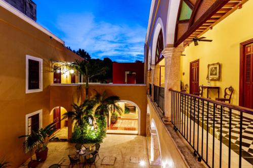 an alleyway in a building with chairs and plants at Hotel Boutique Casa Don Gustavo, Campeche in Campeche