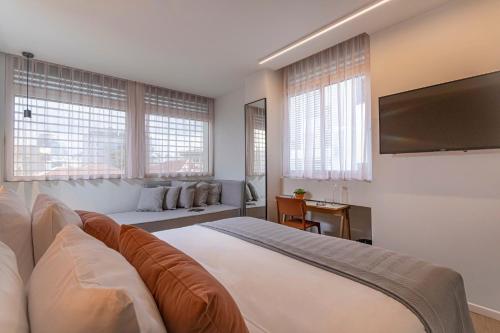 a bedroom with a large bed and a flat screen tv at Artist Hotel - an Atlas Boutique Hotel in Tel Aviv
