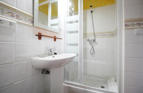 een witte badkamer met een wastafel en een douche bij Villa la Marina SpainSunRentals 1106 in Nerja