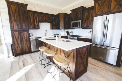 a kitchen with wooden cabinets and a sink and a refrigerator at Kaya Cottages in Dahlonega
