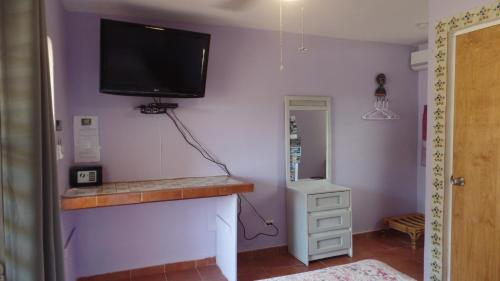 a room with a television and a dresser at Isla Hermosa Guesthouse in Vieques