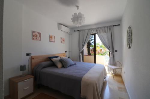 1 dormitorio con 1 cama y puerta corredera de cristal en Apartment Capricho SpainSunRentals 1115, en La Herradura