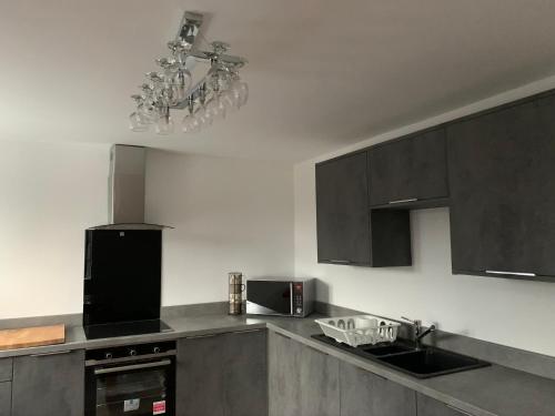 a kitchen with gray cabinets and a chandelier at St George’s Lodge in Halifax